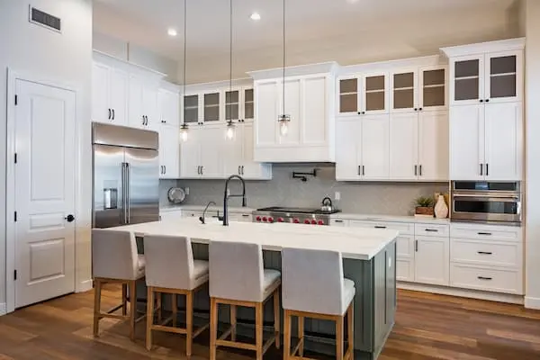 remodeled white kitchen cabinet and light sage island and white countertops
